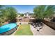 The aerial view shows the backyard with a pool, lawn, fire pit, and a basketball hoop, all enclosed by a block fence at 7274 W State Ave, Glendale, AZ 85303