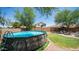 The backyard features an above-ground pool, green lawn, fire pit, and a basketball hoop for outdoor fun at 7274 W State Ave, Glendale, AZ 85303