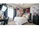 Cozy bedroom features eclectic decor, including posters, and a large window with decorative vines and black curtains at 7274 W State Ave, Glendale, AZ 85303