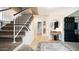 Inviting entryway features staircase with wood railings, large rug, and black door at 7274 W State Ave, Glendale, AZ 85303