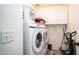 Functional laundry room with stacked washer and dryer, plus overhead cabinet storage at 7274 W State Ave, Glendale, AZ 85303