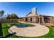 Backyard with a kidney-shaped pool, well-maintained artificial turf, and a covered patio at 8668 N 107Th Dr, Peoria, AZ 85345