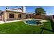 Backyard view featuring a kidney-shaped pool, artificial grass and covered patio at 8668 N 107Th Dr, Peoria, AZ 85345