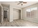 Bedroom with an open closet and wood-look floors looking into the hallway at 8668 N 107Th Dr, Peoria, AZ 85345