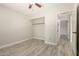 Bedroom with an open closet and wood-look floors looking into the hallway at 8668 N 107Th Dr, Peoria, AZ 85345