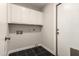 Functional laundry room with overhead cabinets and black tile flooring at 8668 N 107Th Dr, Peoria, AZ 85345