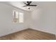 Well-lit bedroom with wood-look flooring and a modern ceiling fan at 934 E Wahalla Ln, Phoenix, AZ 85024