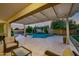 Covered patio offers a comfortable spot to overlook the pool, and landscaped backyard at 23090 S 201St St, Queen Creek, AZ 85142