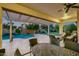 Covered patio is furnished with seating and a dining set, providing shade and overlooks the pool and yard at 23090 S 201St St, Queen Creek, AZ 85142