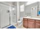 Bathroom with glass enclosed shower, wood cabinet sink, mosaic backsplash, and neutral color scheme at 23090 S 201St St, Queen Creek, AZ 85142