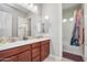 Bathroom featuring double sinks, decorative mirror, and a shower/tub combo at 23090 S 201St St, Queen Creek, AZ 85142