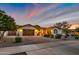Charming single-story home features multiple garages, desert landscaping, and warm exterior lighting at 23090 S 201St St, Queen Creek, AZ 85142