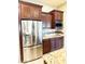 The kitchen is equipped with stainless steel fridge, microwave, granite countertops and dark wood cabinetry at 23090 S 201St St, Queen Creek, AZ 85142