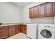 Laundry room featuring modern washer and dryer, spacious countertops, and ample cabinet space at 23090 S 201St St, Queen Creek, AZ 85142