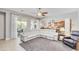 Open concept living room with a white sectional sofa, tile floors, and sliding glass doors to the patio at 23090 S 201St St, Queen Creek, AZ 85142