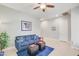 Comfortable living room with blue couch, ceiling fan, and neutral color palette, creating a cozy atmosphere at 23090 S 201St St, Queen Creek, AZ 85142