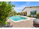 Inviting pool features a baja shelf, lush landscaping and covered patio, perfect for outdoor relaxation at 23090 S 201St St, Queen Creek, AZ 85142