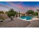 Sparkling pool with a rock waterfall feature surrounded by lush landscaping and pavers at 23090 S 201St St, Queen Creek, AZ 85142