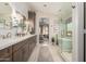 An elegant bathroom boasting double sinks, stylish mirrors, a walk-in shower, and a luxurious bathtub at 10342 E Obispo Ave, Mesa, AZ 85212