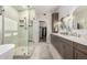 A modern bathroom featuring a glass-enclosed shower, a soaking tub, and double sinks with stylish fixtures at 10342 E Obispo Ave, Mesa, AZ 85212