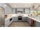 Bright kitchen with grey cabinets, stainless steel appliances, white subway tile backsplash, and open shelving at 10342 E Obispo Ave, Mesa, AZ 85212