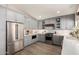 A contemporary kitchen featuring stainless steel appliances, shaker cabinets and sleek, white countertops and tile backsplash at 10342 E Obispo Ave, Mesa, AZ 85212