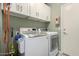 Functional laundry room featuring a washer, dryer, and ample cabinet space at 10342 E Obispo Ave, Mesa, AZ 85212