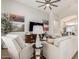Spacious and bright living room featuring wood-look floors, a ceiling fan, and comfortable seating at 10342 E Obispo Ave, Mesa, AZ 85212