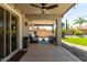 Covered outdoor patio featuring comfortable seating, ceiling fan, and lush backyard view at 10342 E Obispo Ave, Mesa, AZ 85212