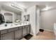 Modern bathroom featuring a gray double sink vanity, sleek tile flooring, and contemporary lighting fixtures at 1147 E Harvest Rd, San Tan Valley, AZ 85140