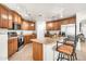 Well-lit kitchen with wooden cabinets, tile flooring, and a central island with bar seating at 1147 E Harvest Rd, San Tan Valley, AZ 85140