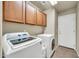 Well-lit laundry room featuring cabinets and modern washer and dryer units, maximizing space and convenience at 1147 E Harvest Rd, San Tan Valley, AZ 85140