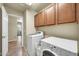 Well-lit laundry room with tile floors, white washer/dryer, and ample storage cabinetry at 1147 E Harvest Rd, San Tan Valley, AZ 85140