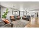 Spacious living room with hardwood floors, a large rug, and gray sofas with orange pillows at 1147 E Harvest Rd, San Tan Valley, AZ 85140