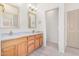 Bright bathroom with double sinks, wood cabinets, and a doorway to the water closet at 13020 W Highland Ave, Litchfield Park, AZ 85340