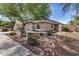 Home exterior showing driveway, neutral paint, tile roof, and low-maintenance landscaping at 13020 W Highland Ave, Litchfield Park, AZ 85340