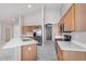 Modern kitchen features wood cabinets, stainless appliances, a quartz island, and modern flooring at 13020 W Highland Ave, Litchfield Park, AZ 85340
