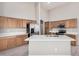 Kitchen with center island, stainless appliances, quartz countertops, and light wood cabinets at 13020 W Highland Ave, Litchfield Park, AZ 85340