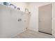 Clean laundry room with storage shelving and a rear entry door at 13020 W Highland Ave, Litchfield Park, AZ 85340