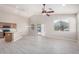 Open-concept living room flows to kitchen and features a ceiling fan and light wood floors at 13020 W Highland Ave, Litchfield Park, AZ 85340