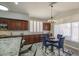 Eat-in kitchen showcasing a granite-topped island, dark wood cabinets, and an adjacent dining space with a chandelier at 14039 S 33Rd Way, Phoenix, AZ 85044