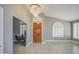 Bright foyer featuring a chandelier, wood door, and views into an adjacent room with plantation shutters at 14039 S 33Rd Way, Phoenix, AZ 85044