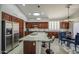 Modern kitchen with island seating, stainless steel refrigerator, rich cabinetry, and adjacent dining area at 14039 S 33Rd Way, Phoenix, AZ 85044