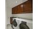 Laundry room equipped with a sink, dark wood cabinets, and modern washer and dryer units at 14039 S 33Rd Way, Phoenix, AZ 85044