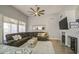Comfortable living room with a dark leather sectional, ceiling fan, fireplace, and a view into the dining area at 14039 S 33Rd Way, Phoenix, AZ 85044