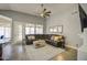 Inviting living room featuring a comfortable, dark leather sectional, ceiling fan, and lots of natural light at 14039 S 33Rd Way, Phoenix, AZ 85044