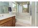 Bathroom featuring tub, vanity, and shower with blue walls and natural light from windows at 15630 N 20Th St, Phoenix, AZ 85022