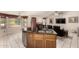 Kitchen island with bar seating, stainless steel dishwasher, and view to the living room at 15630 N 20Th St, Phoenix, AZ 85022