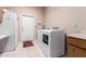 Bright laundry room features a white washer and dryer, utility sink, and direct access to the exterior at 15630 N 20Th St, Phoenix, AZ 85022