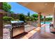 Outdoor grill on the patio near the pool, with a beautifully landscaped garden area and rock features at 15630 N 20Th St, Phoenix, AZ 85022